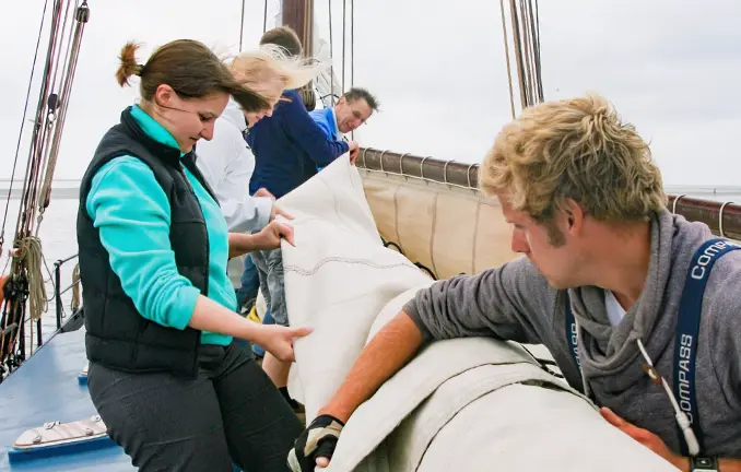 Ein Plattbodenschiff unter Segel steuern Vor der Sandbank Richel werden die Segel geborgen